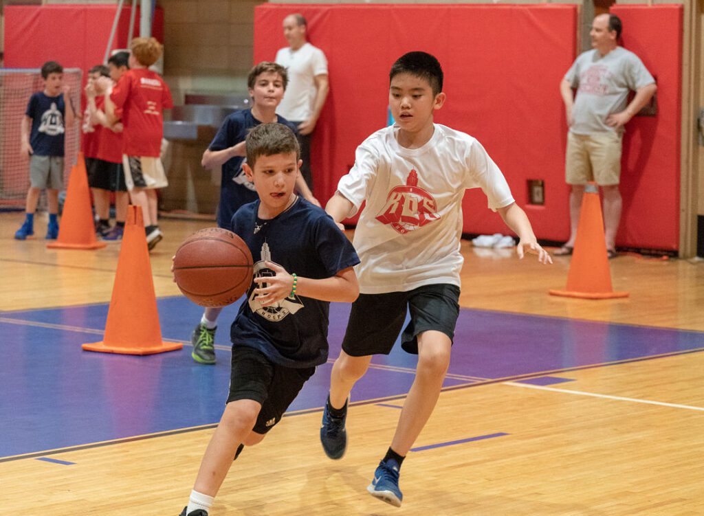 Boy dribbling past defender in gym