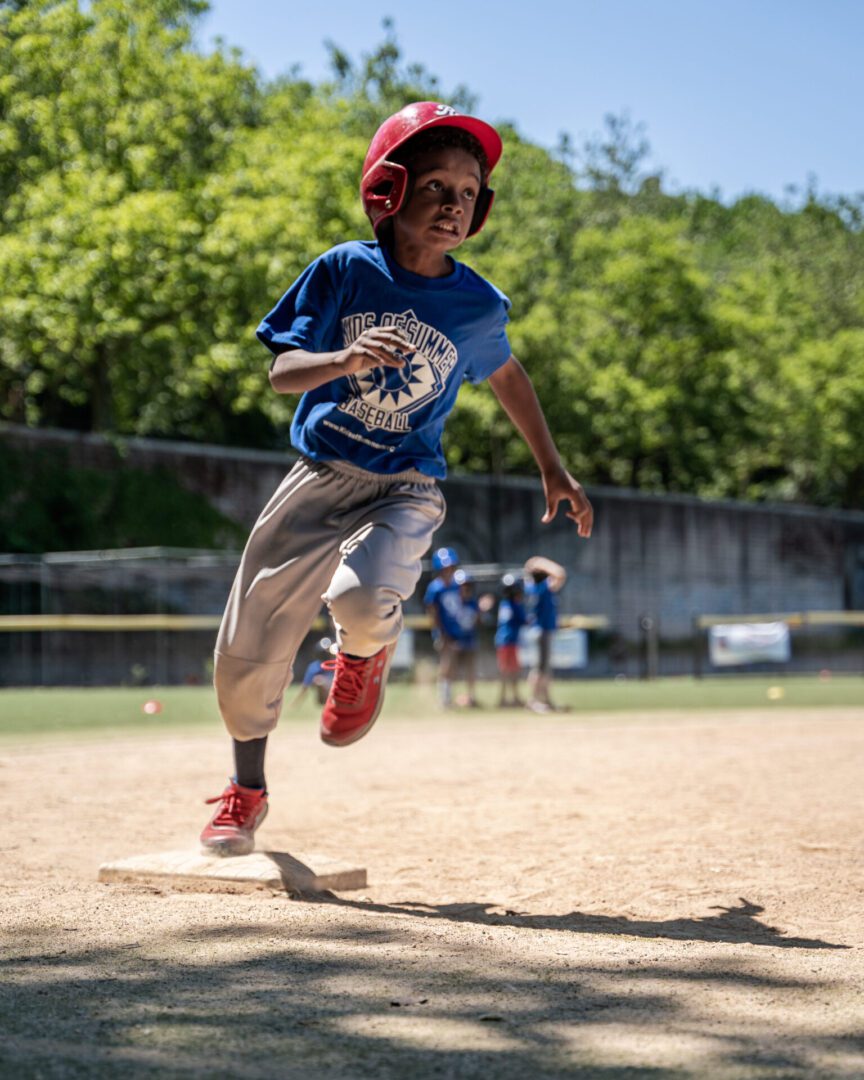 Young baseball player jumping over base