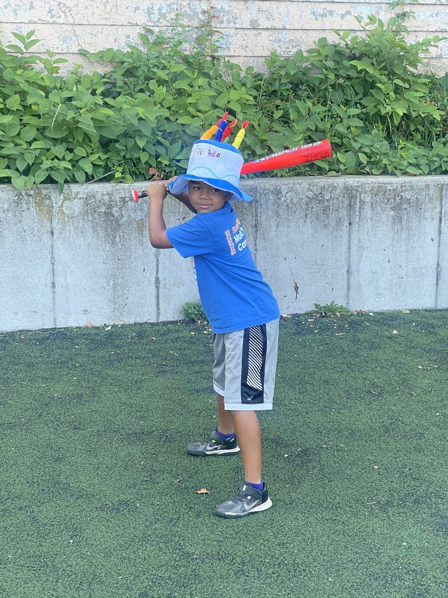 Child batting with birthday hat