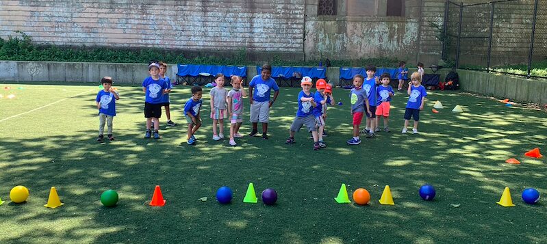 Kids in blue shirts on grassy field