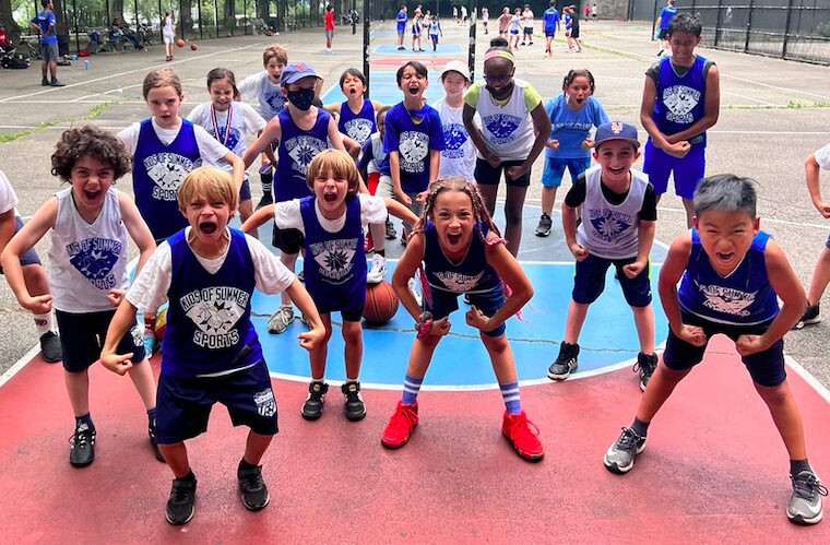 Excited kids posing on outdoor basketball court