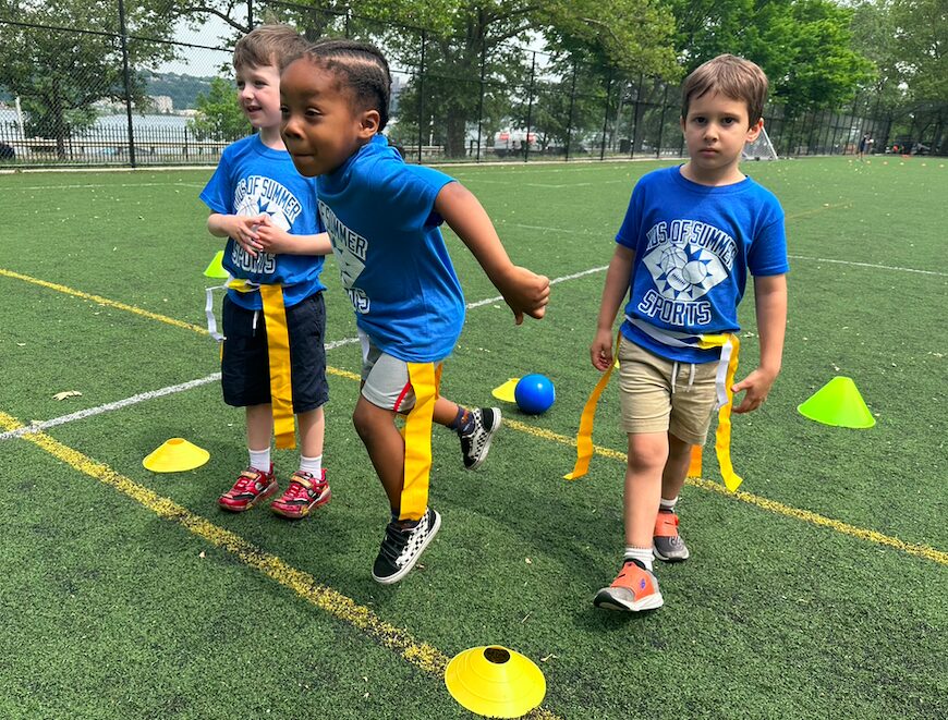 Kids playing flag football on turf